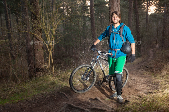 Young man with his ATB in the forest (Misc) Photo Download