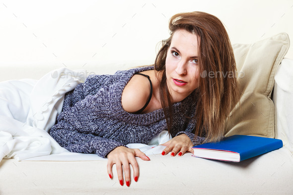 Woman relaxing after lunch with book on couch
