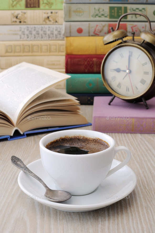 A cup of coffee on a table among books (Misc) Photo Download