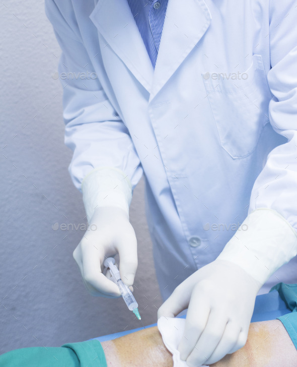 Surgeon doctor injecting patient in hospital clinic