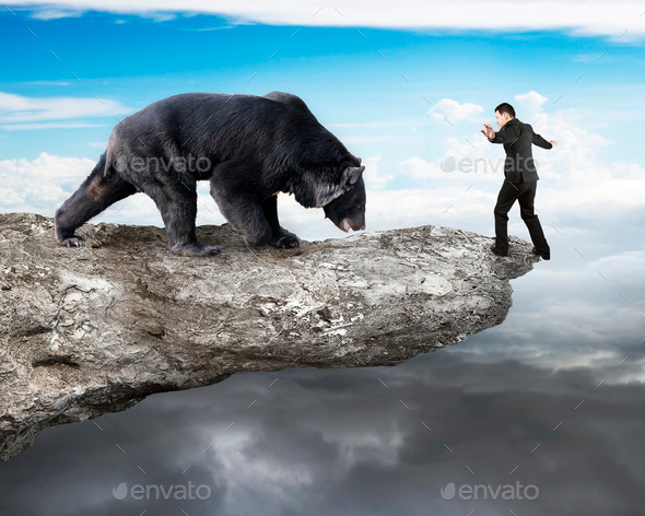 Businessman against black bear balancing on cliff with sky cloudscape (Misc) Photo Download