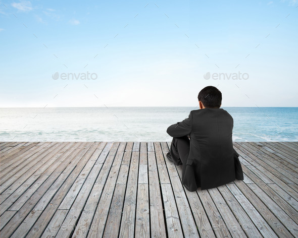 Rear view businessman hands holding knee sitting with sky sea (Misc) Photo Download