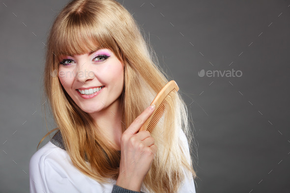 Closeup woman combing her hair with comb