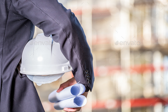 White helmet and blueprints on construction site (Misc) Photo Download