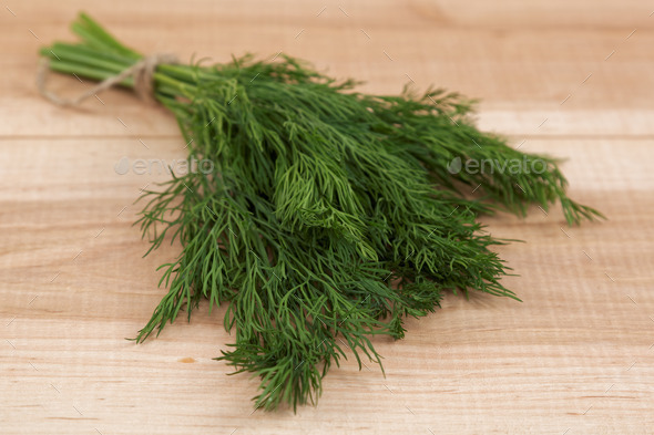 Bunch of fresh dill on a wooden board.