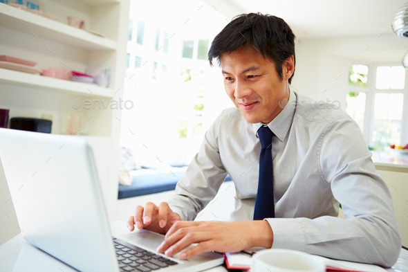 Asian Businessman Working From Home On Laptop