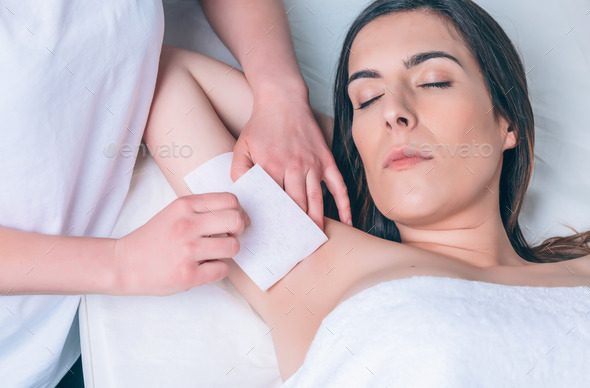 Beautician hands doing depilation in woman armpit with wax strip (Misc) Photo Download