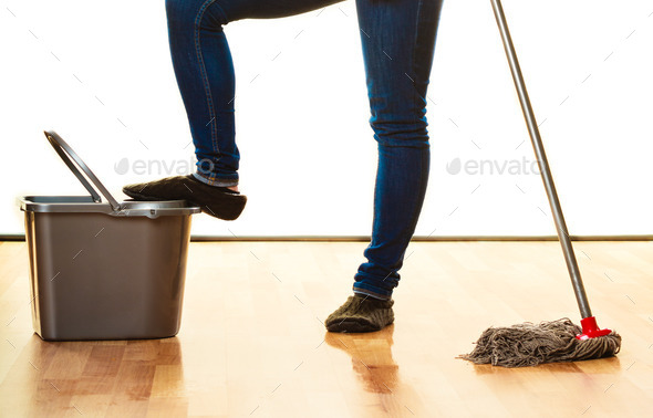 legs of cleaning woman with mop bucket