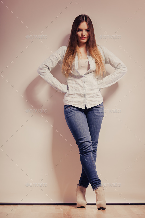 Portrait of a young woman posing against a grey background. Royalty-Free  Stock Image - Storyblocks