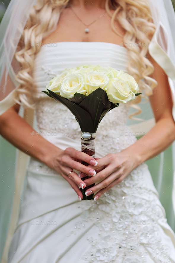 Bride is holding a bouquet in hand (Misc) Photo Download