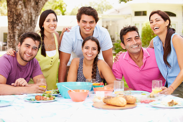 Group Of Friends Celebrating Enjoying Meal In Garden At Home
