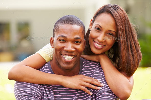 Portrait Of Happy Young Couple In Garden