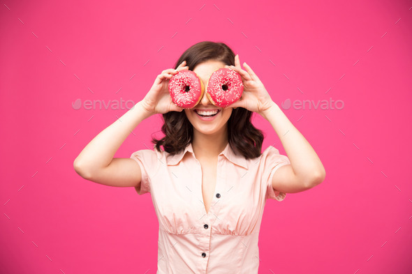 Woman covering her eyes with donut