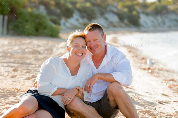 attractive beautiful couple in love sitting on the beach in romantic summer holidays