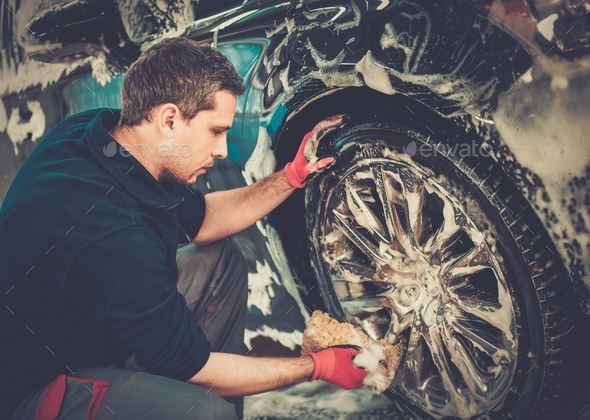 Man worker washing car's alloy wheels on a car wash (Misc) Photo Download