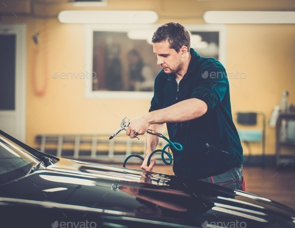 Man worker drying car on a car wash