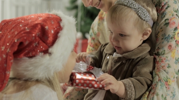 Mom Sits With Her Baby Girl And Christmas Gifts