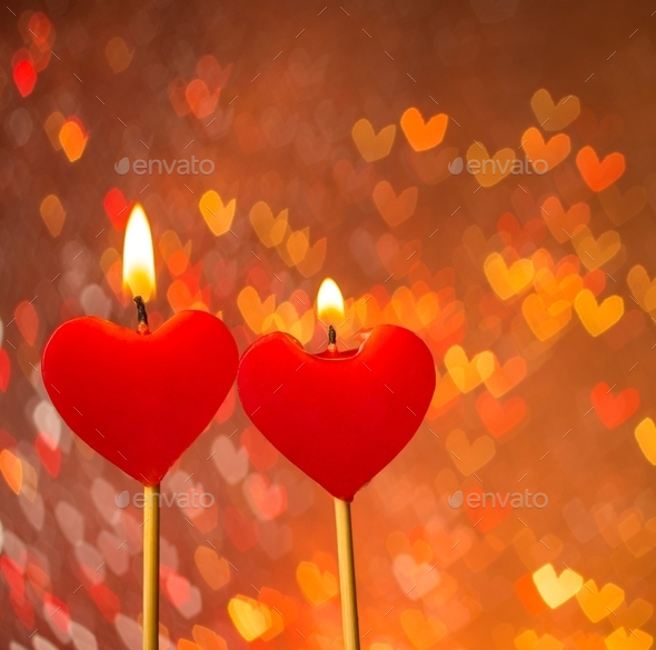 red hearts candles on warm hearts bokeh as background