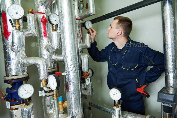 heating engineer repairman in boiler room