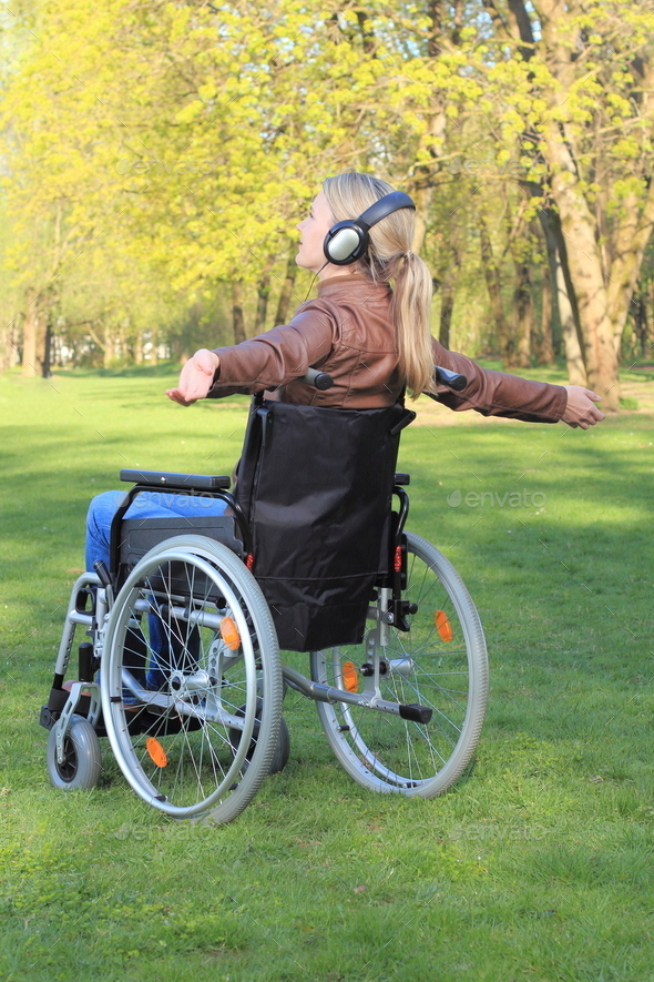 Woman happy in a wheelchair with arms spread