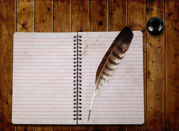 Open notebook and feather with ink bottle
