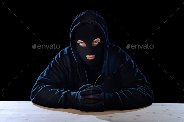 criminal or terrorist man in mask hidden identity in secret illegal activity crime concept