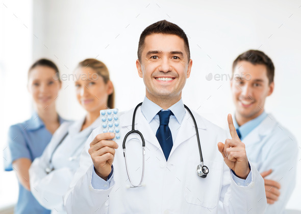 smiling male doctor in white coat with tablets