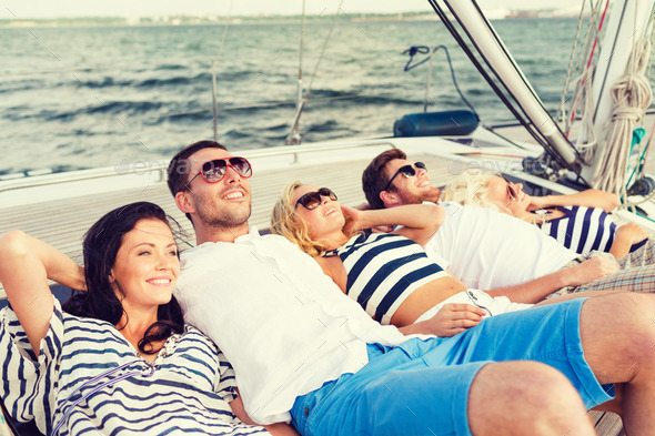 smiling friends lying on yacht deck