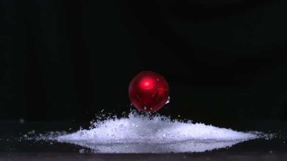 Christmas Bauble Falling Onto Pile Of Glitter On White Background Christmas Bauble Falling Onto Pile Of Glitter On White Background
