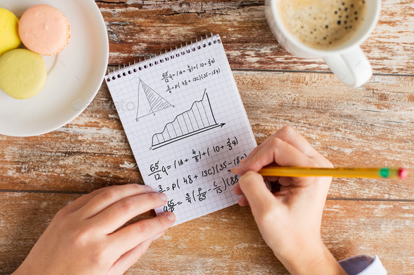 close up of hands writing mathematical equation (Misc) Photo Download