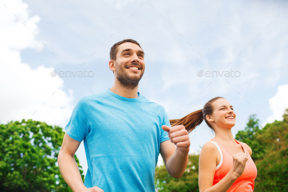 smiling couple running outdoors (Misc) Photo Download