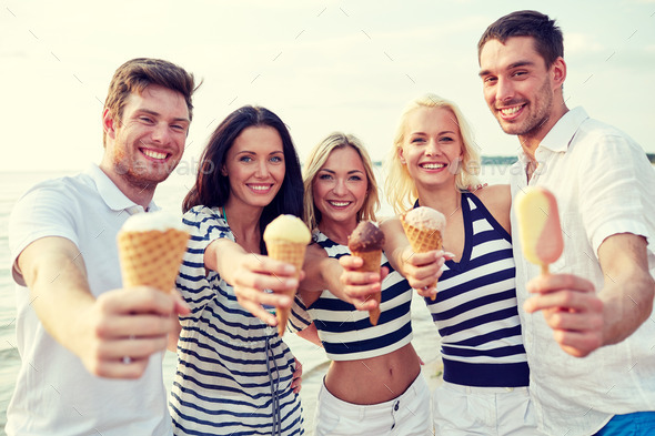 smiling friends eating ice cream on beach (Misc) Photo Download