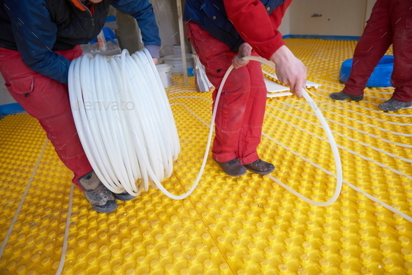 workers installing underfloor heating system