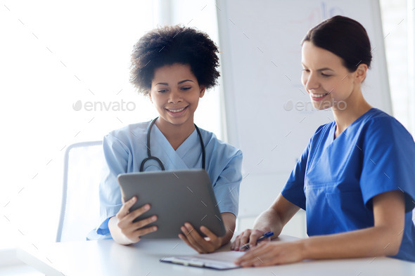 happy doctors with tablet pc meeting at hospital (Misc) Photo Download