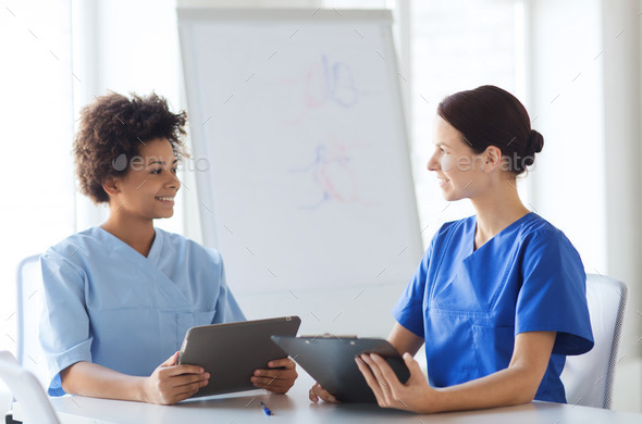 happy doctors with tablet pc meeting at hospital (Misc) Photo Download