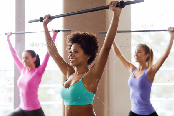 group of people exercising with bars in gym
