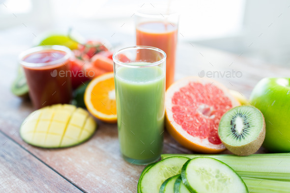 close up of fresh juice glass and fruits on table