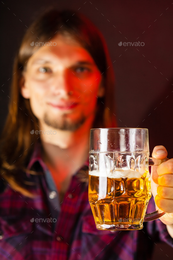 handsome young man holding a mug of beer
