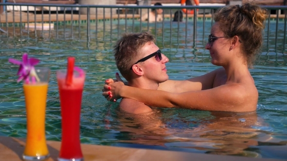 Couple Relaxing In Sunny Swimming Pool Couple Relaxing In Sunny Swimming Pool