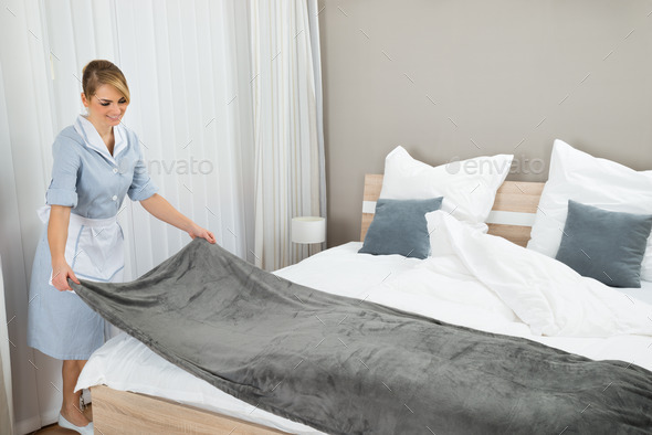 Female Housekeeping Worker Making Bed
