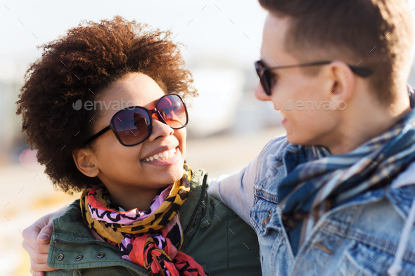 happy teenage friends in shades talking outdoors