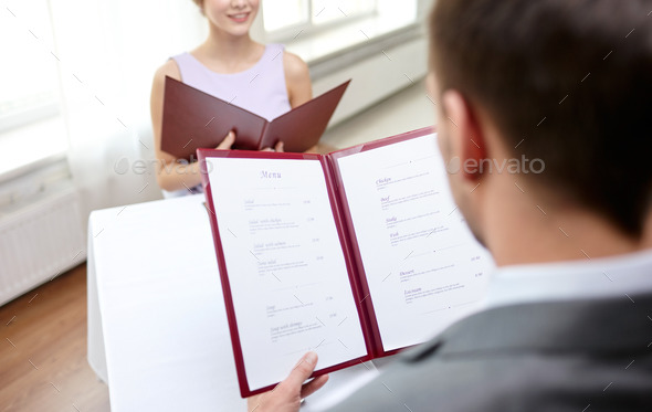 close up of couple with menu at restaurant