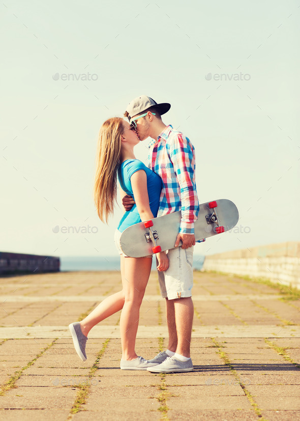 couple with skateboard kissing outdoors (Misc) Photo Download