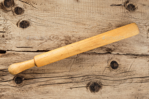 Old rolling pin on a wooden board