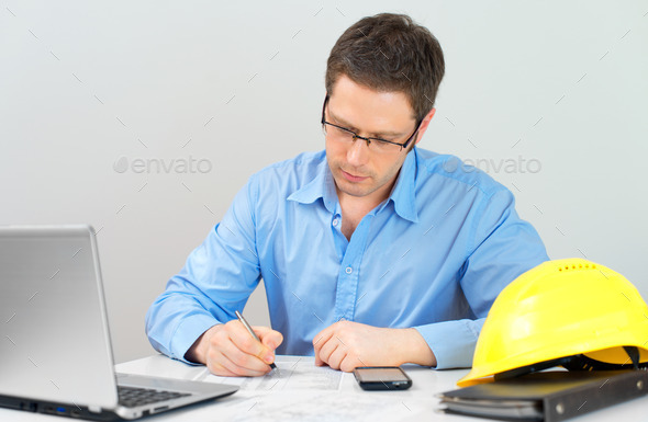 Architect working on house plan at his workplace.