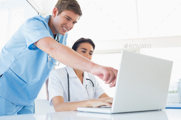 Doctors working with laptop computer in medical office (Misc) Photo Download