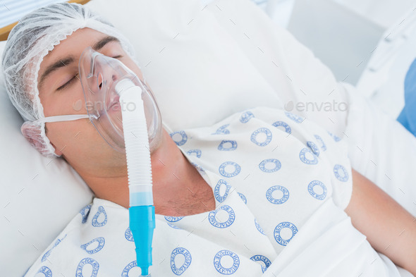Patient lying with oxygen mask in hospital room