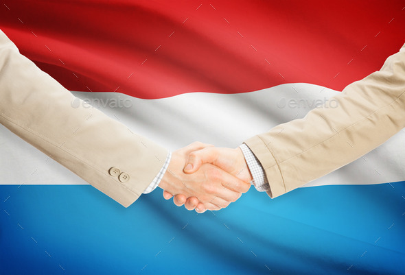 Businessmen handshake with flag on background - Luxembourg