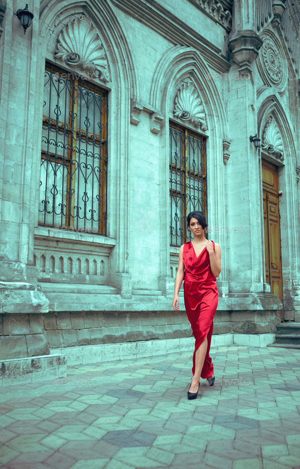 Woman in red dress gothic home in front