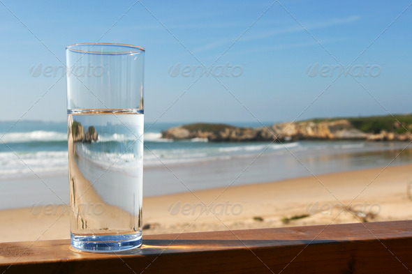 water in glass with view on ocean
